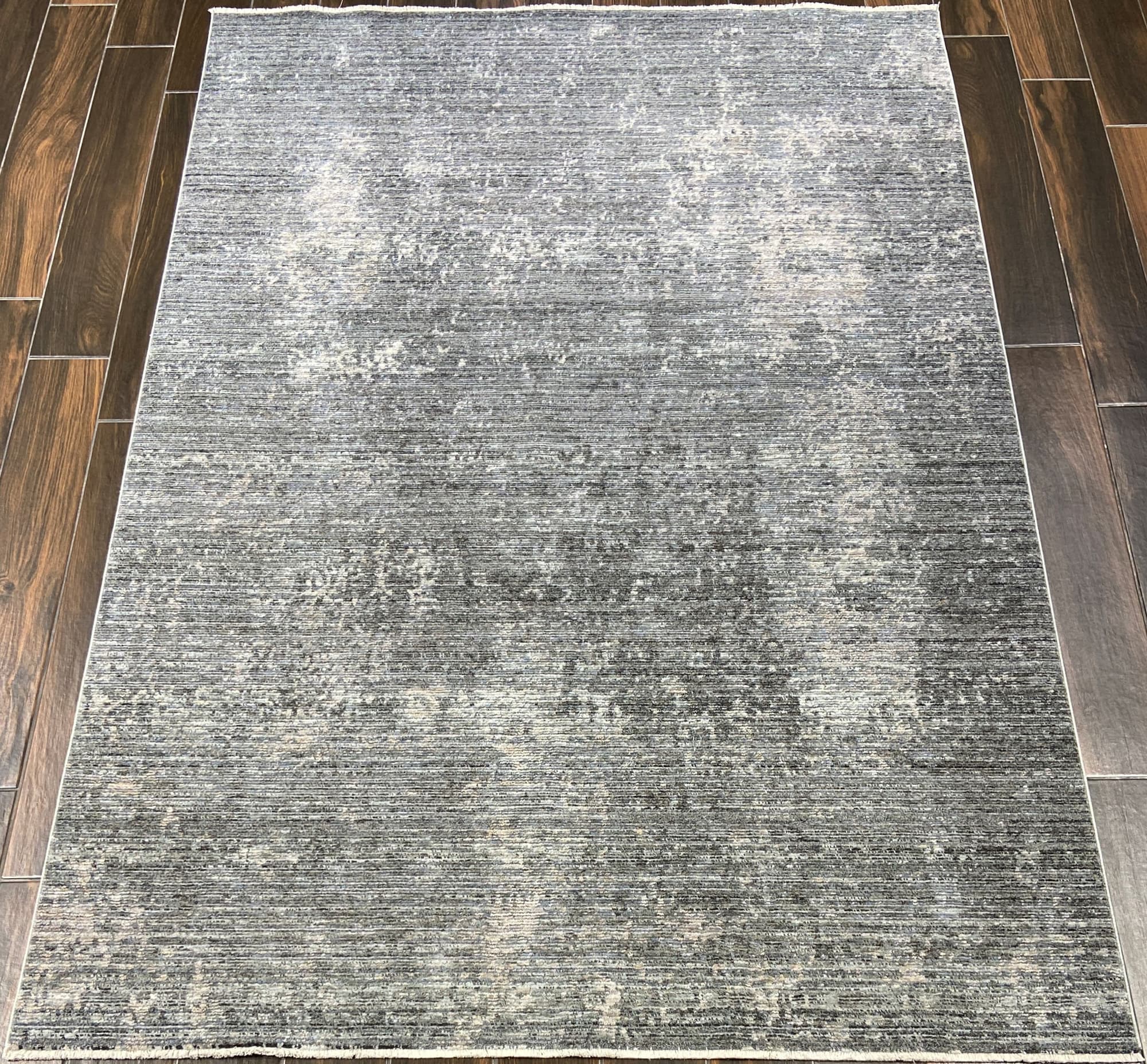 Mosaic, a Kyra space-dyed polyester rug in grey/navy, styled in a room